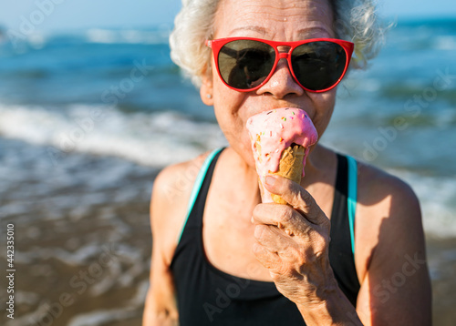 Obraz na plátně Senior woman eating an ice-cream