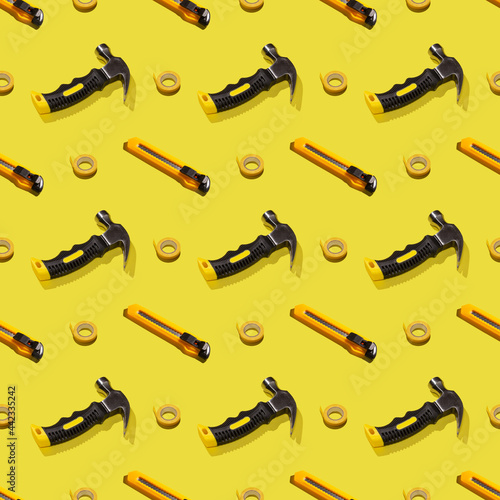 Hammers  knives  and duct tape on a yellow background  pattern  hard shadows. Construction tools  repairs. Background for the design.