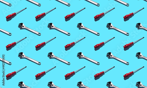 Screwdriver and wrench, pattern on a blue background. Construction tools, repairs. Background for the design.