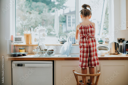 Tableau sur toile Little girl doing the dishes