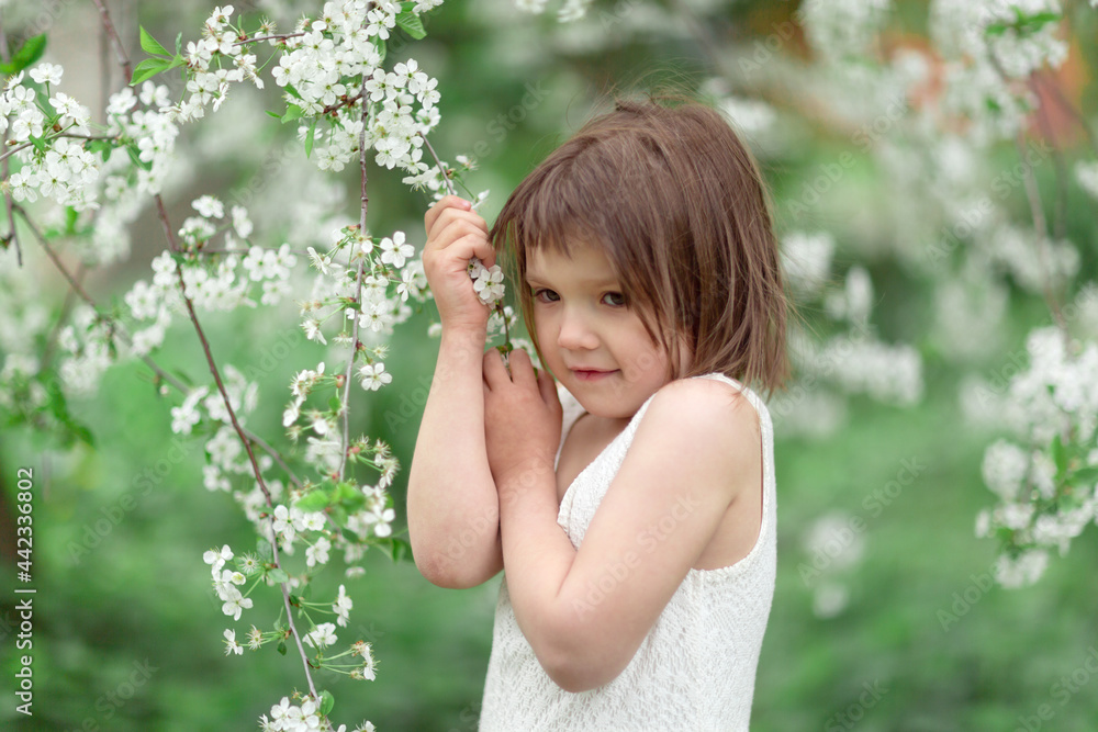 Adorable European kid girl with cherry blossom flowers, spring and self-care, tender child girl photo, childhood Adorable European kid girl with cherry blossom flowers, spring and self-care, tender child girl photo, childhood
