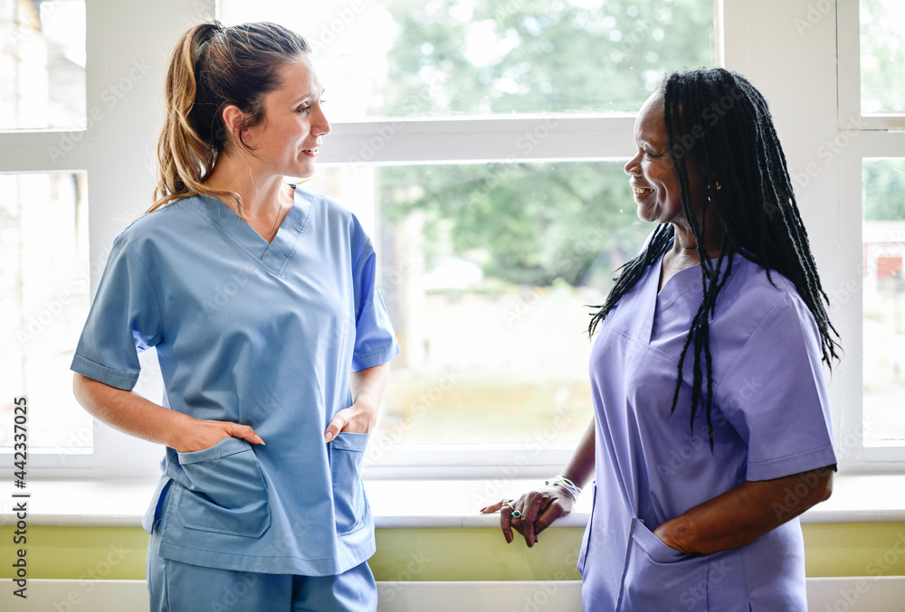 Nurses Having A Conversation In The Hospital Hallway Stock Photo