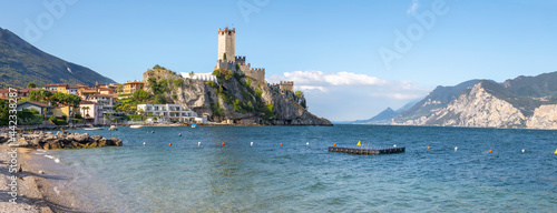 Malcesine - The beach of Lago di Garda lake with the town and castle in the background.