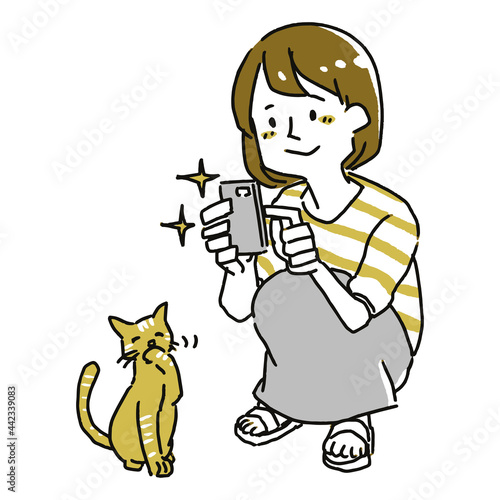 スマホのカメラで猫の写真を撮る女性