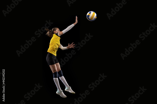 Female professional volleyball player with ball isolated on black studio background. The athlete, exercise, action, sport, healthy lifestyle, training, fitness concept. © master1305