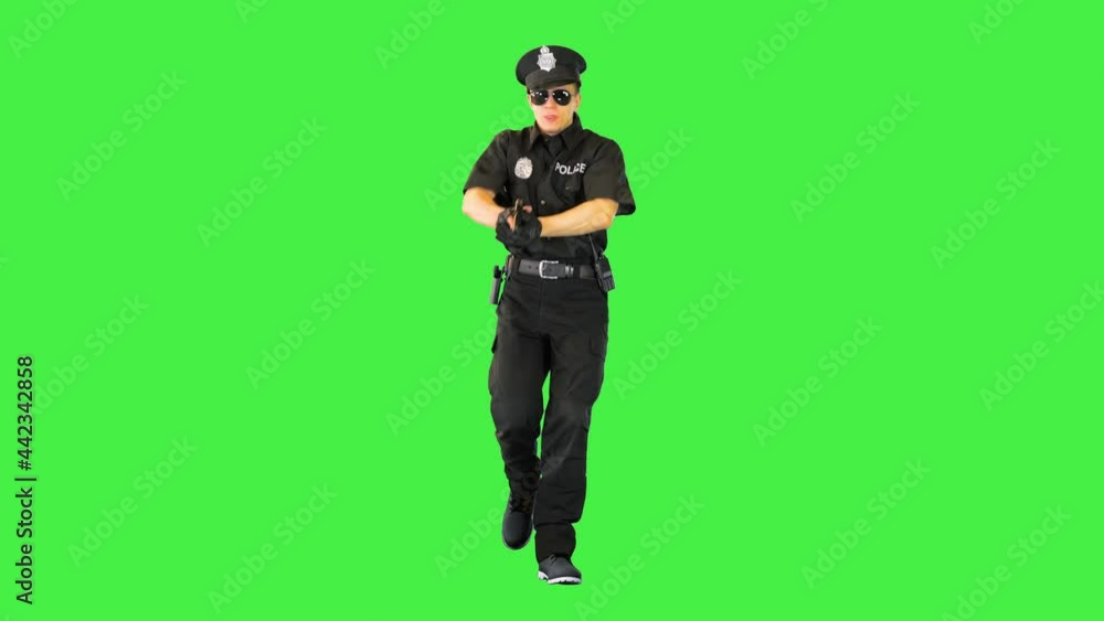 Policeman in uniform runs aiming with a gun on a Green Screen, Chroma Key.