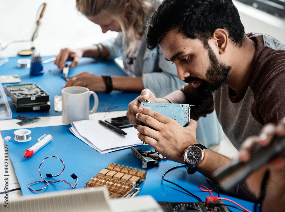 Electrical technicians working on electronics parts Electrical technicians working on electronics parts