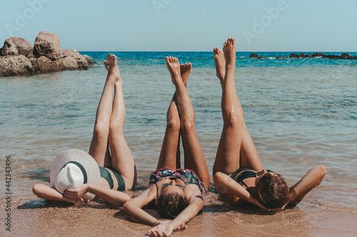 Group of beautiful young women have a rest on a beach. Friends walking on the beach