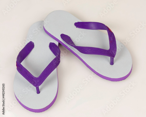 Swallow sandals white mixed with purple on a bright background. Swallow sandals are very comfortable to use for everyday footwear. Lightweight and also flexible. Free space for your ad. Shoe mockup.