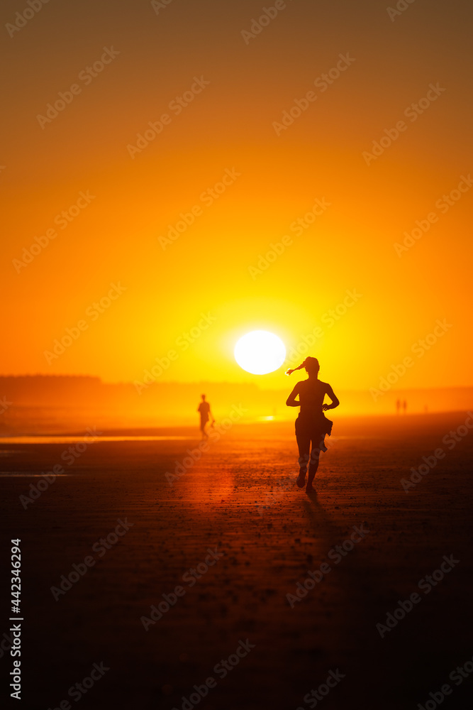 Atleta  corriéndo maratón en el desierto al ocaso. 
Mujer corriendo bajo sol asfixiante.