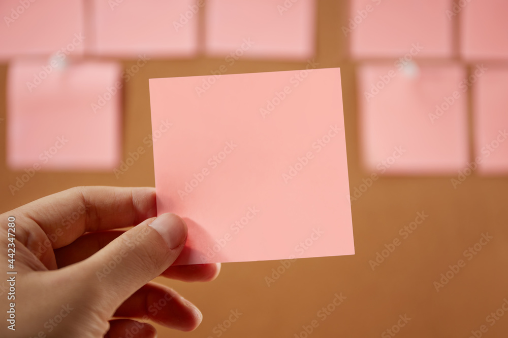 Obraz premium Hand holding a red empty sticky note