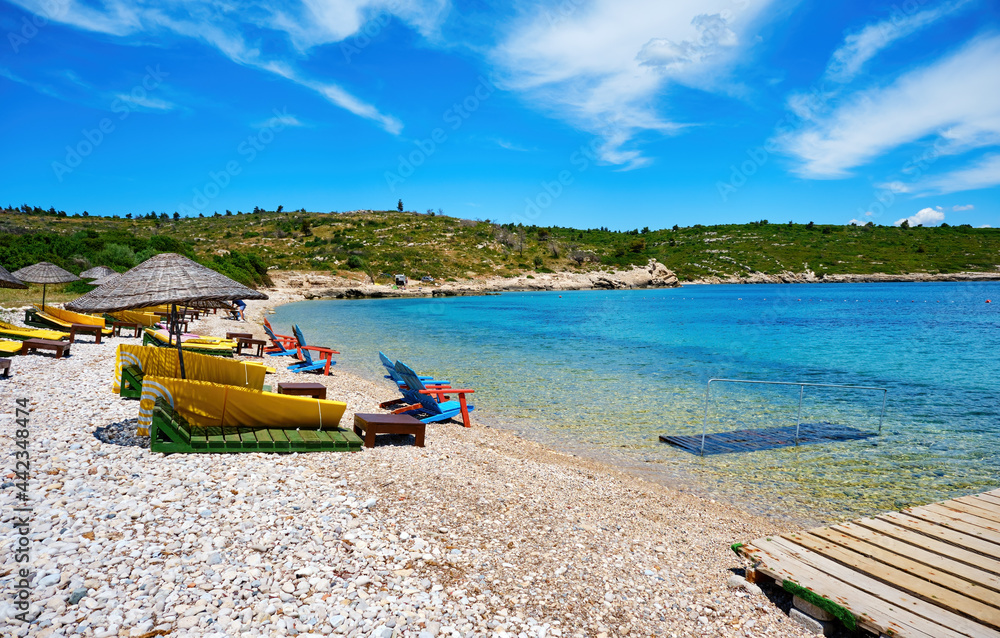 Beach, sea and sunbeds at Demircili bay in Urla, İzmir, Turkey. Holiday or travel destinations.