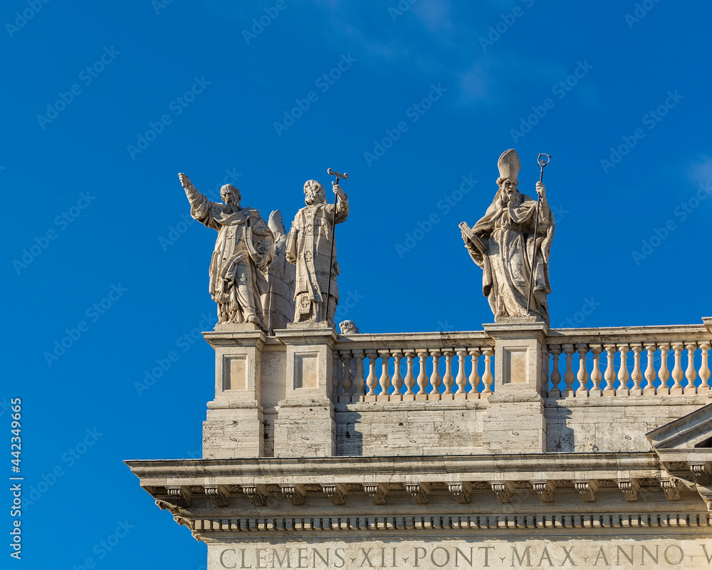 Statues on the roof of the Papal Archbasilica of St. John in Lateran (Basilica di San Giovanni in Laterano) in a sunny day, Italy, Rome