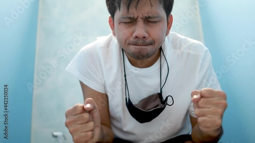 Asian man sitting on toilet bowls feel liberated, diarrhea, constipation photo