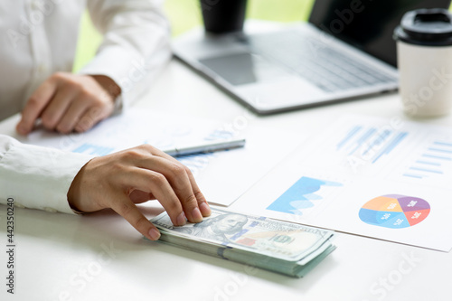 Close up of Business woman with calculator counting money and making notes at home,savings, finances, economy and home concept.