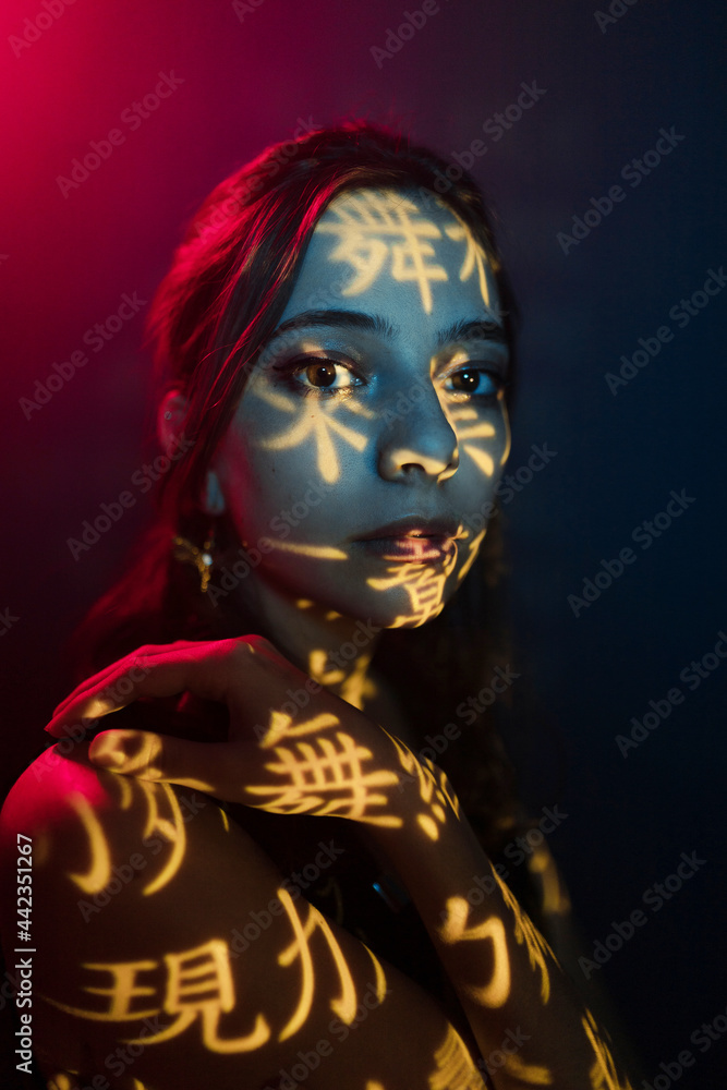 Young woman with light projection on skin Young woman with light projection on skin