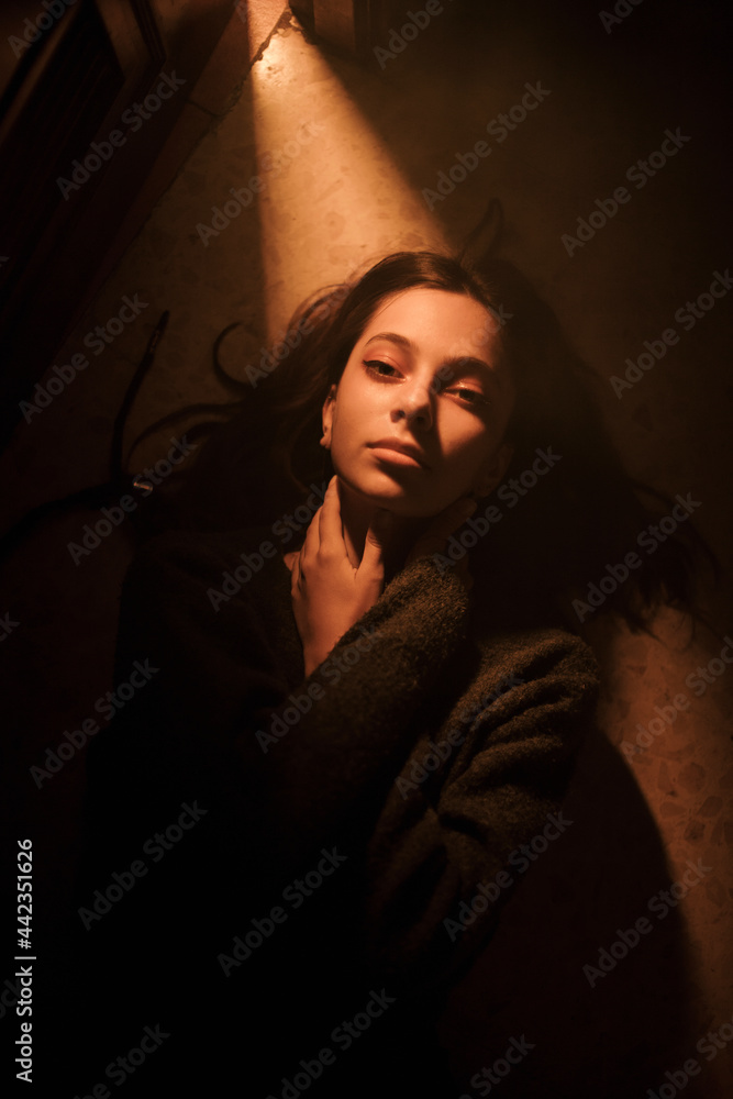 Lonely woman lying in dark room with opened door Lonely woman lying in dark room with opened door