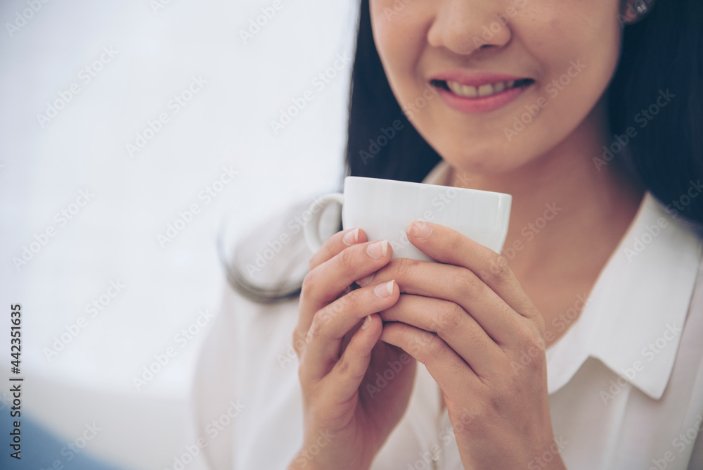 Close up hands of woman sitting office desk holding sweet coffee cup relax and enjoy with happy time. Hot coffee mug in hand. Woman holding coffee cup relaxing after work at office warm taste in cafe Close up hands of woman sitting office desk holding sweet coffee cup relax and enjoy with happy time. Hot coffee mug in hand. Woman holding coffee cup relaxing after work at office warm taste in cafe