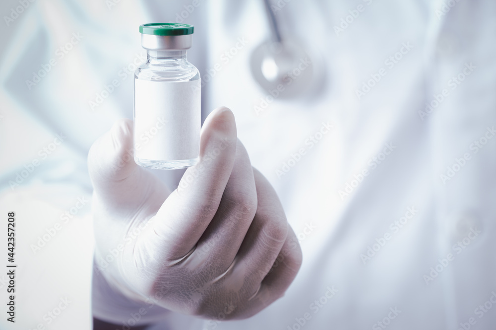 Doctor holding single bottle vial of vaccine for children or adults. Concept fight against virus. Medical health care concept vaccination hypodermic injection treatment vintage background. Doctor holding single bottle vial of vaccine for children or adults. Concept fight against virus. Medical health care concept vaccination hypodermic injection treatment vintage background.