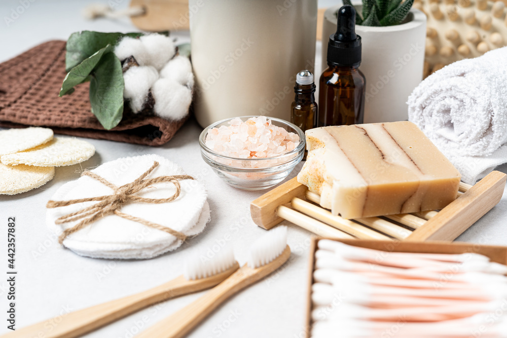Natural bathroom and home spa tools. Zero waste sustainable lifestyle concept. Bamboo toothbrush, natural soap bar, cotton pads, homemade DIY beauty products in reusable bottles on white background.