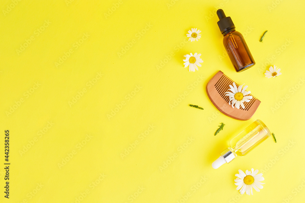 Organic vegan natural cosmetics for hair. Flat Lay composition of Chamomile flowers and cosmetic bottles with essential oil. Natural beauty. top view. Space for text Organic vegan natural cosmetics for hair. Flat Lay composition of Chamomile flowers and cosmetic bottles with essential oil. Natural beauty. top view. Space for text