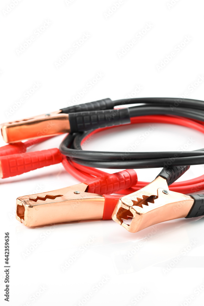 Red and black battery extension cable for vehicle isolated on white background, emergency device in car
