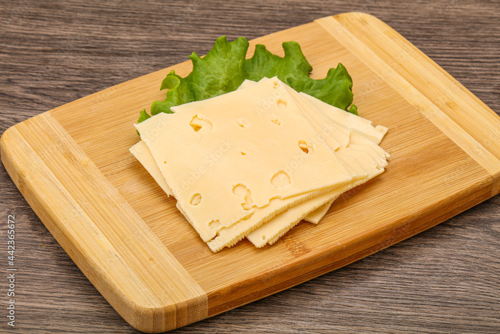 Sliced yellow cheese over board Sliced yellow cheese over board
