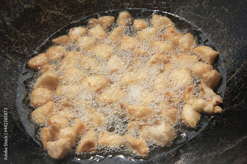 Wallpaper Mural Large chunks of raw lamb fat dumba are fried in oil with bubbles in a black cauldron close-up, cooking food Torontodigital.ca