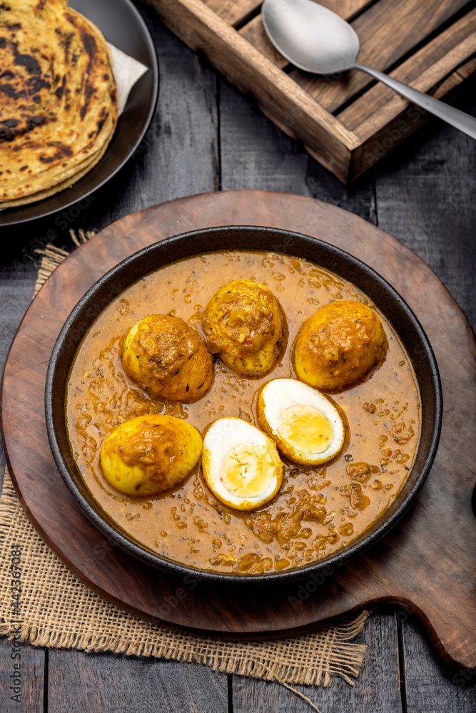 Fried egg curry or Anda Masala served in a bowl with lachha parantha Fried egg curry or Anda Masala served in a bowl with lachha parantha