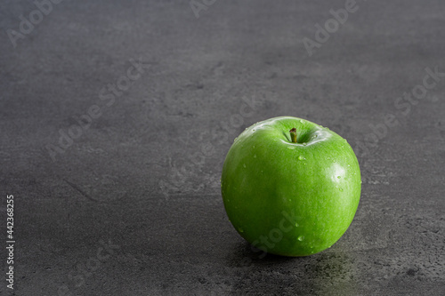 Grüner Apfel auf grauer Struktur