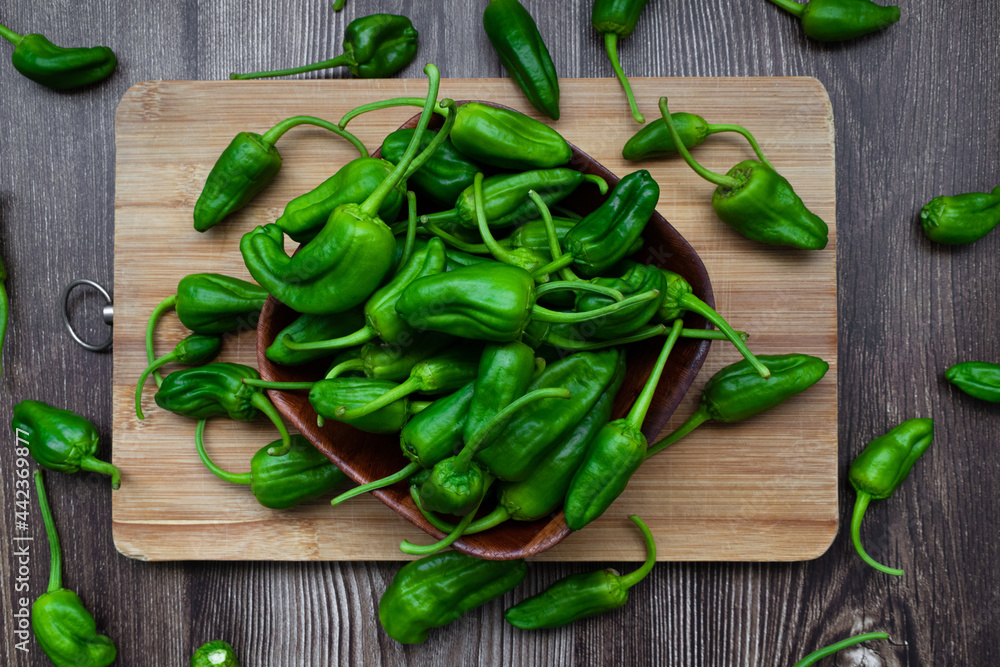 Top view of freshly harvested green peppers on a rustic wooden table Top view of freshly harvested green peppers on a rustic wooden table