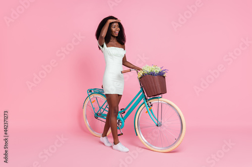 Full size profile portrait of attractive dark skin lady hand on forehead look empty space isolated on pink color background © deagreez