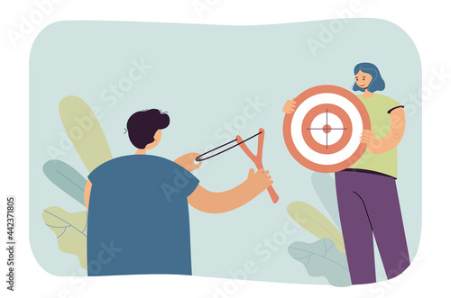 Boy aiming his slingshot at target that girl holding. Flat vector illustration. Boy holding slingshot, aiming, shooting at target. Hobby, fun, childhood, friendship, sport concept for banner design