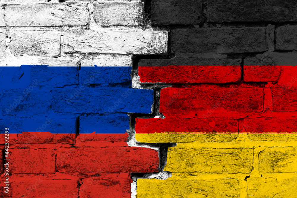 Concept of the relationship between Russia and Germany with two painted flags on a damaged brick wall