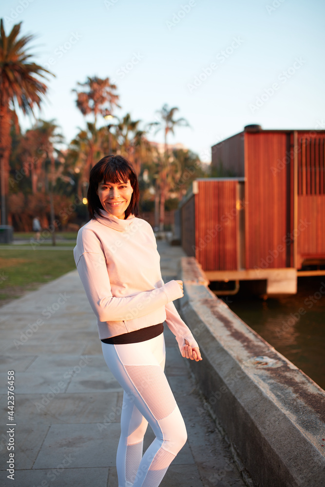 Woman harbourside in a happy mood at sunrise Woman harbourside in a happy mood at sunrise