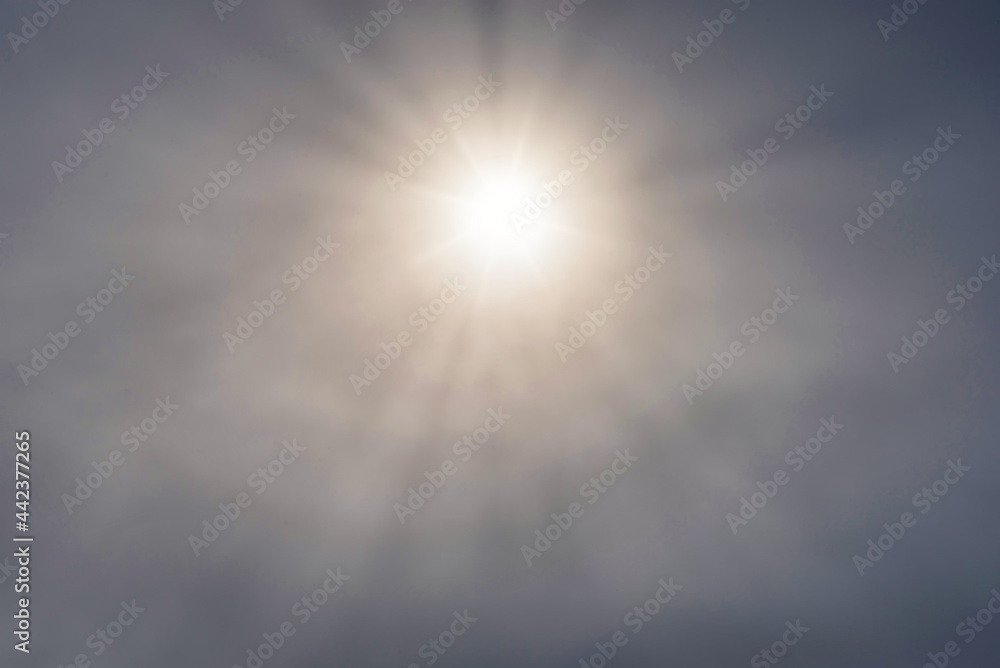 Sun Glowing Through Clouds in a Summer Sky