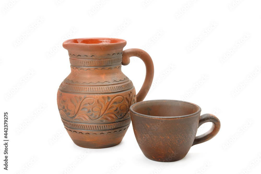Clay jug and mug isolated on white .