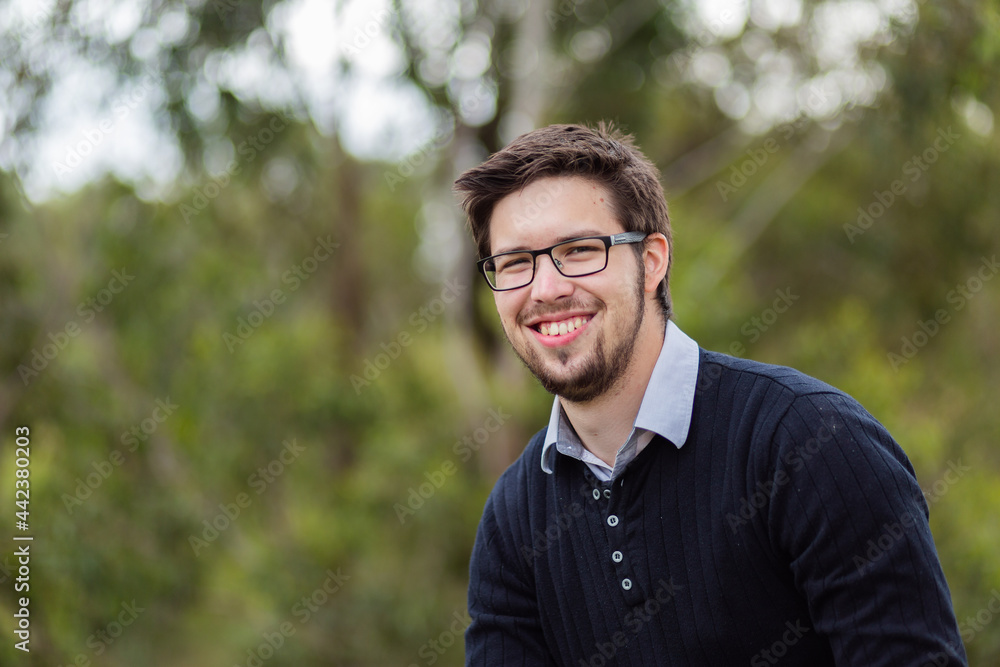 Portrait of smiling bearded man in his twenties outside Portrait of smiling bearded man in his twenties outside