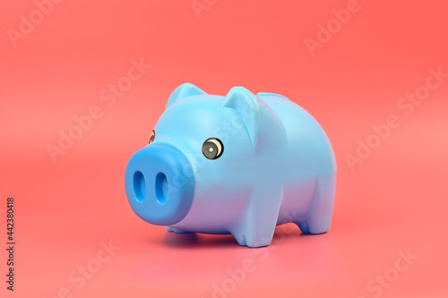 Blue piggy bank isolated on pink background, saving money concept