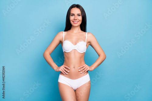 Portrait of pretty skinny girl put arms on waist demonstrate figure freshness isolated on blue color background