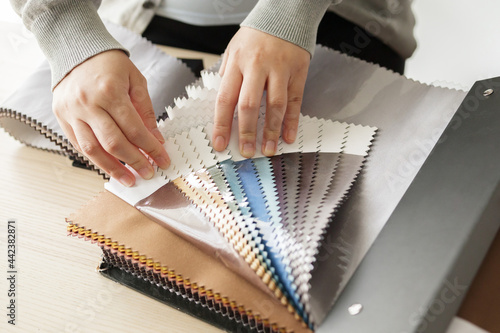 female designer with fabric color samples choosing textile for curtains