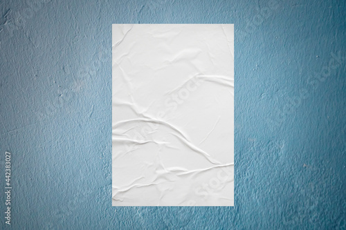 Blank white wheatpaste glued paper poster mockup on concrete wall background © Piman Khrutmuang