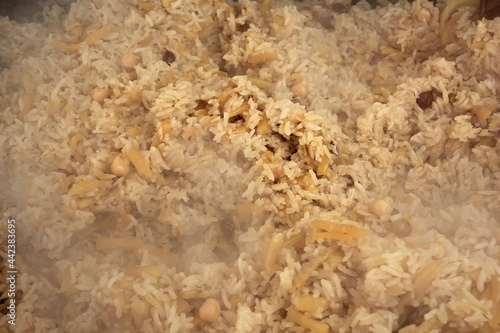 Wallpaper Mural Freshly prepared delicious uzbek pilaf close-up, rice, yellow carrots, chickpeas, spices, cooking, steam is coming Torontodigital.ca