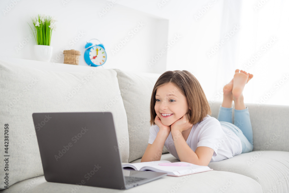 Photo portrait little girl laying on couch watch online lesson remote aducation at home Photo portrait little girl laying on couch watch online lesson remote aducation at home