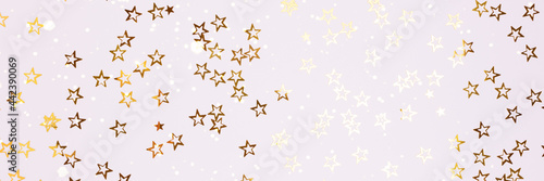 Banner with shiny gold colored stars confetti scattered on a white background.
