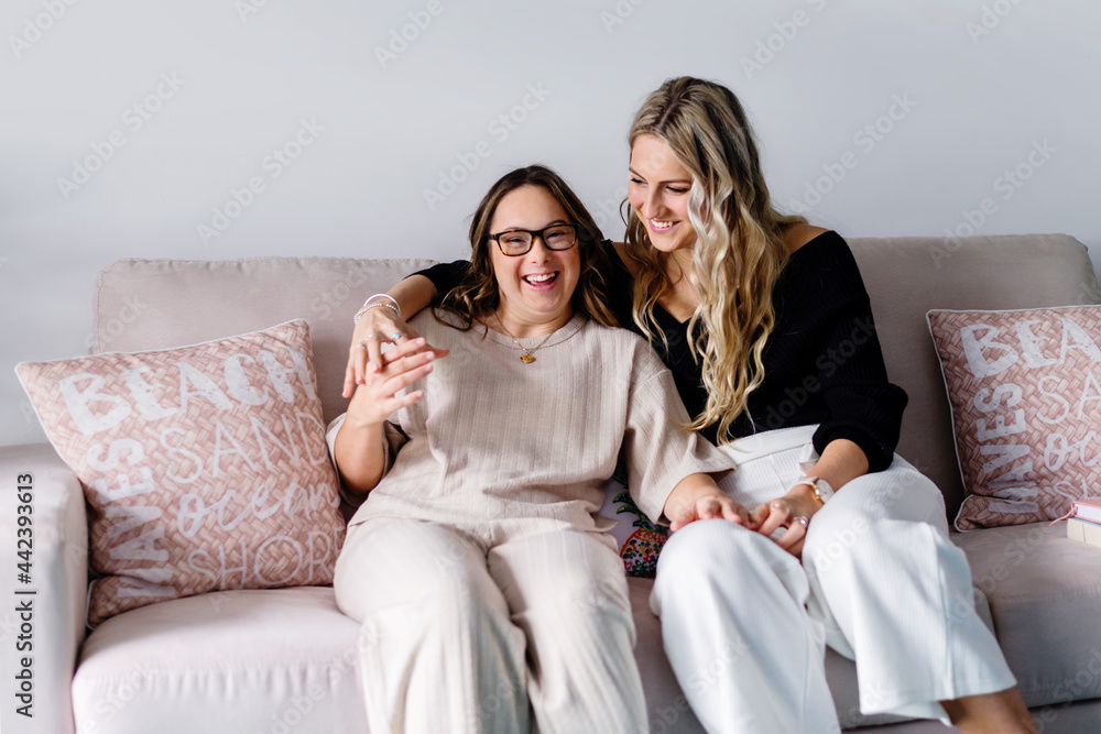 two women sitting on sofa, having a laugh. two women sitting on sofa, having a laugh.