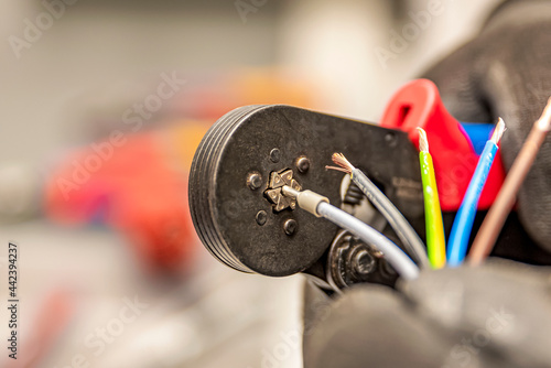Wire crimping tool. Close-up crimper. A man holds a wire crimper. Equipment for the electrician. Copy space. photo
