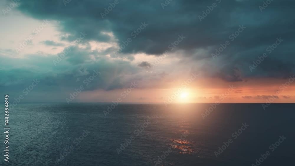 Dramatic colorful ocean sunset. Aerial slow motion flight. Bright orange sun reflection in sea waves and dark blue clouds. Nature background. Beautiful wild travel landscape. Exotic summer vacation. Dramatic colorful ocean sunset. Aerial slow motion flight. Bright orange sun reflection in sea waves and dark blue clouds. Nature background. Beautiful wild travel landscape. Exotic summer vacation.