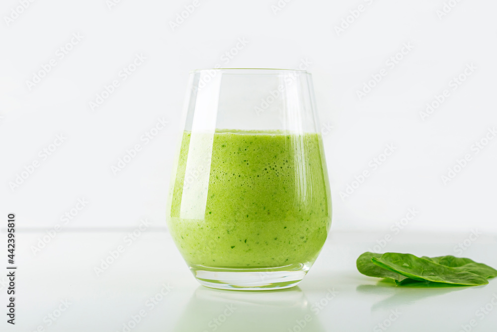 Green smoothie from spinach, apple, cucumber and soy milk in glass on white background. Home cooking. Vegan healthy detox eating, dietary and weght loss drink