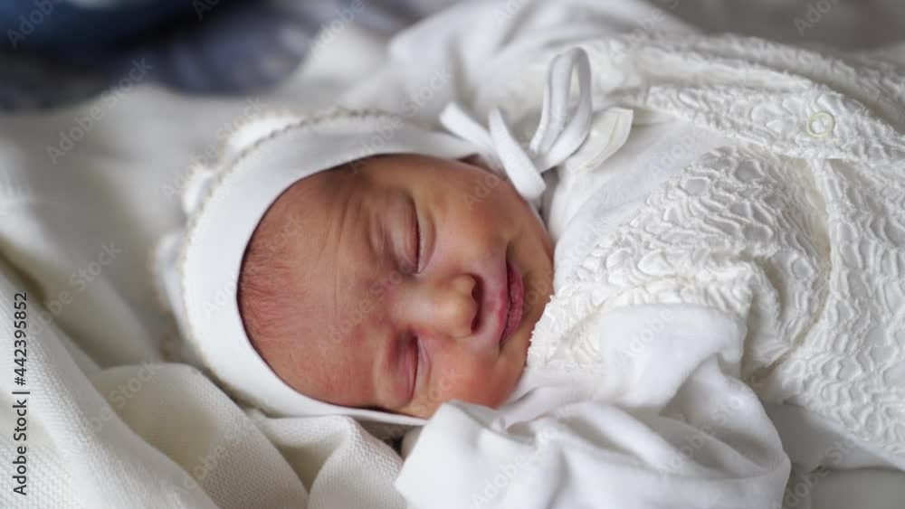 Newborn baby sleeps in white clothes. attire for discharge from the hospital.